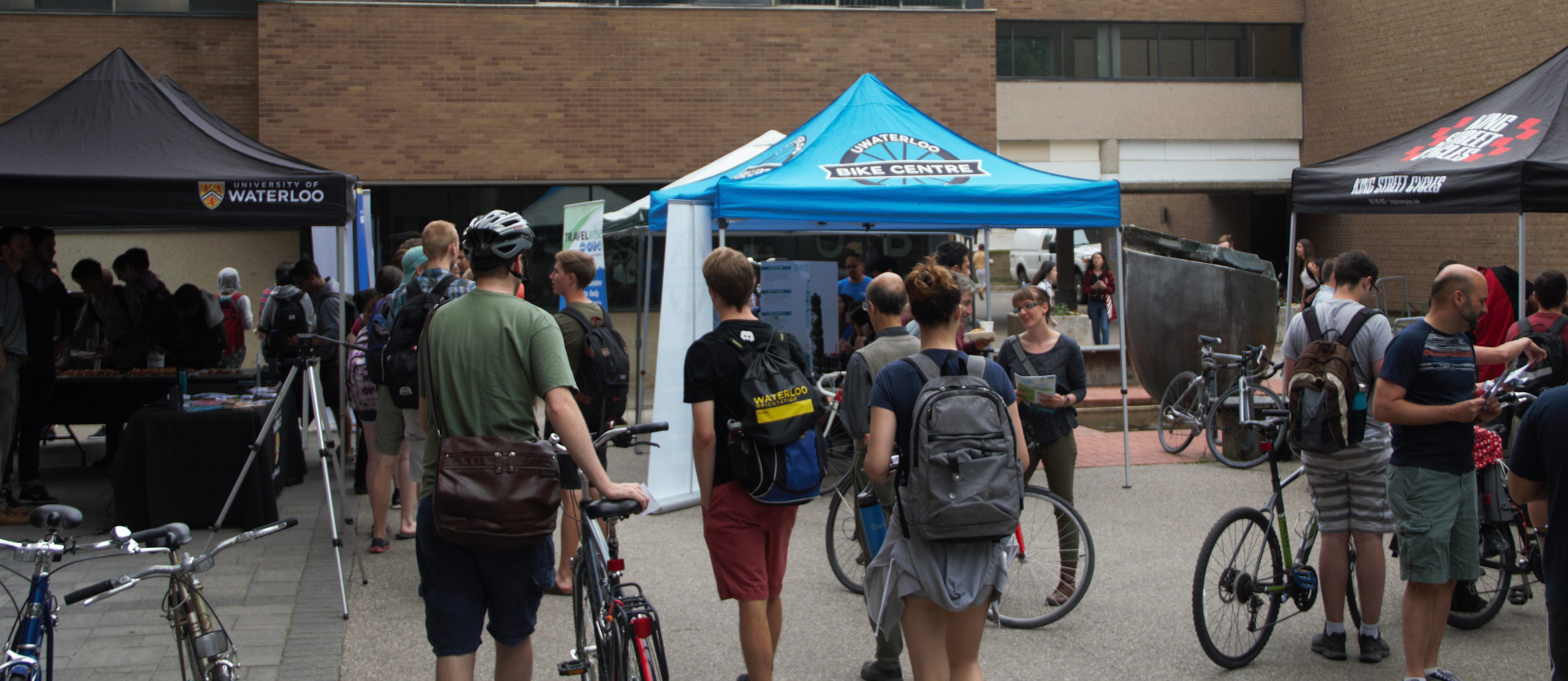 Faculty, staff, and students lining up for free bike tuneups at the Bike Month celebration in June, 2018.